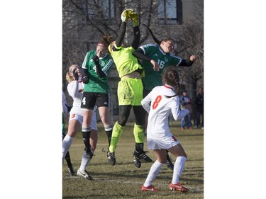 University of Saskatchewan Huskies strikers Jenelle Zapski (L) and Leesa Eggum can't get ahead before University of Calgary Dinos goalkeeper Samantha Anneliese Chang-Foidl knocks the ball away during the second half of CIS women's soccer playoff action, November 8, 2015.