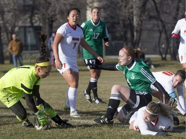University of Saskatchewan Huskies striker Jenelle Zapski battles for the ball with University of Calgary Dinos forward Amy Hockings (R) before goalkeeper Samantha Anneliese Chang-Foidl makes the save during the second half of CIS women's soccer playoff action, November 8, 2015.