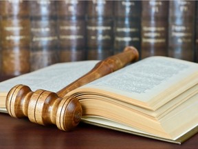 Local Input~ Wood gavel and old yellowed book on the background of shelves of old books. Credit: fotolia. ORG XMIT: POS1409261346474981