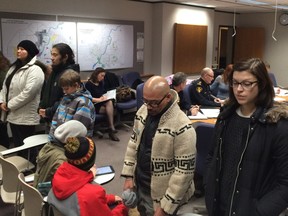 A group of people turned their back on a meeting of the Saskatoon board of police commissioners on Dec. 10, 2015 to show their opposition to the practice of police street checks.