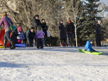 People slide down a small hill at Winterlude behind Victoria School, December 5, 2015.