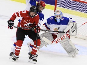 Canada's Emily Clark, left, vies with Russia's Svetlana Tkachyova in front of Russia's goalkeeper Maria Sorokina during the 2015 IIHF Ice Hockey Women's World Championship group A match between Canada and Russia at Malmo Isstadion in Malmo, southern Sweden, Sunday, March 29, 2015.