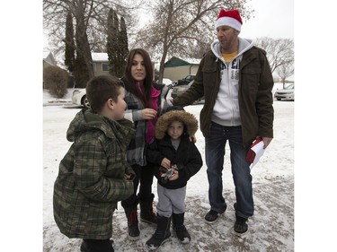 Radio station C95, the Kinsmen Club of Saskatoon and other sponsors surprised Janelle Bruneau and her sons, Tyler and Trey, with a Christmas Wish, December 14, 2015.  They were surprised with toys, groceries, gifts and even a car — courtesy of Precision Auto Body. Here Rob Suski greets the family.