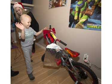 Radio station C95, the Kinsmen Club of Saskatoon and other sponsors surprised Janelle Bruneau and her sons, Tyler and Trey, with a Christmas Wish, December 14, 2015.  They were surprised with toys, groceries, gifts and even a car — courtesy of Precision Auto Body. Here Trey sees his new bike.