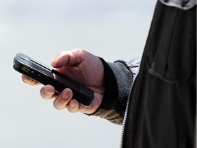 A pedestrian uses a smartphone as he walks along Market Street on June 5, 2013 in San Francisco, California.  A