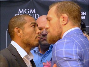 UFC featherweight champion Jose Aldo, left, of Brazil, and challenger (The Notorious) Conor McGregor, right, of Ireland, face off as UFC President Dana White looks on