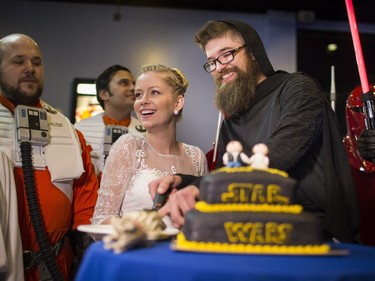 Meg Thompson and Anthony Nygren cut a Star Wars wedding cake during a wedding ceremony at the opening show of  Star Wars: The Force Awakens on Thursday, Dec. 17, 2015, in at the Great Clips IMAX Theatre at the Minnesota Zoo in Apple Valley, Minn.