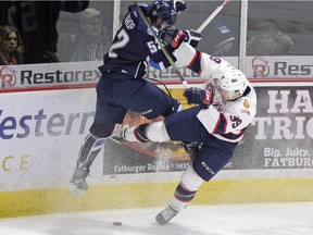 Saskatoon Blades' Anthony Bishop, left, and Regina Pats' Lane Zablocki get tangled up as the go for the loose puck during first period WHL action at the Brandt Centre in Regina on Tuesday.