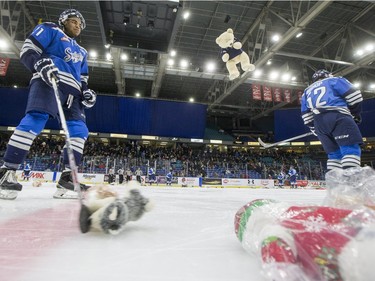 Saskatoon Blades forward Lukus MacKenzie (L) moves up teddy bears after his team scored their first goal against the Kelowna Rockets during first period WHL action, December 19, 2015.