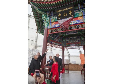 Dignitaries remove a cover from a sign during the unveiling of the new Chinese Ting artwork event in Victoria Park, December 12, 2015.