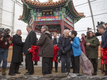 Dignitaries remove a cover from a plaque during the unveiling of the new Chinese Ting artwork event in Victoria Park, December 12, 2015.