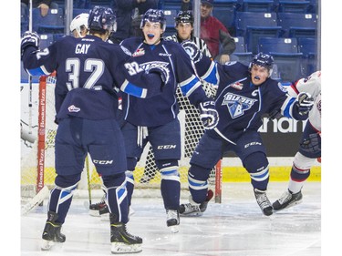 Saskatoon Blades forward Connor Gay (L) and forward Nick Zajac (R) celebrate forward Cameron Hebig's game-tying goal against the Regina Pats during third period WHL action, December 13, 2015.