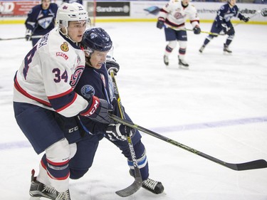 Saskatoon Blades forward Mason McCarty and Regina Pats defenceman Jared Freadrich battle for the puck during second period WHL action, December 13, 2015.