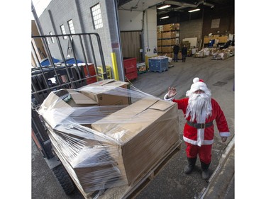 Rosenau Transport's decorated semi-truck and trailer pulled up to the Saskatoon Food Bank and Learning Centre and, with the help of Santa for one pallet, the very special delivery of about 6,000 pounds of food and money was unloaded, December 18, 2015.