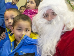 SASKATOON, SASK.; DECEMBER 18,2014- Issac and Levi McDonald on Santa Claus's knee in Fond Du Lac airport, Saskatchewan's far north, meeting children there taking a tour of many northern communities  with the help of Tranwest Airlines,  December 18, 2014.  (Gord Waldner/The StarPhoenix)