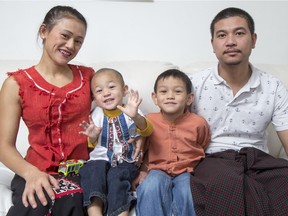 Nay Myo Hein, right, his wife is Hay Mar Zin, left, and their children Moe, age 5, and Wai, age 2 pose for a photograph at their home on Sunday, Dec. 20, 2015. (
