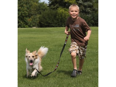 A boy runs with his dog in Kinsmen Park on July 23, 2015 in Saskatoon.