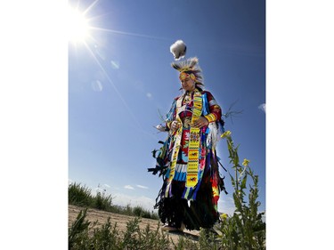 Jordan Thunderchild blesses the ground of this completed section of the Meewasin Valley Trail at Wanuskewin Heritage Park, doing a grass dance during a ceremony officially opening the trail, June 5, 2015.