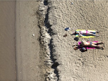 Hot weather and sun brings people out to the sand below the Broadway Bridge, June 8, 2015.