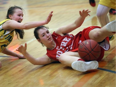 Regina Sheldon Williams Spartans' Alyssa Star (L) and Notre Dame Hounds' Morgan Sapara battle for the ball at Hoopla in 5A action on March 27, 2015.