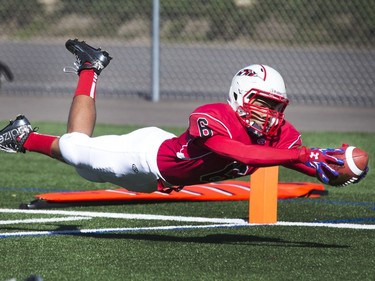 Bedford Road Redhawks #6 Justyn Lightle scores the first touchdown of the game, diving across the goal line in a high school football game against the Mount Royal Mustangs, September 10, 2015.