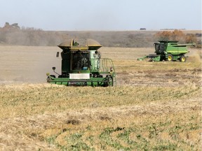 Farmers work in a field south of Delisle.