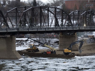 Work continues on building an earthen berm under Victoria Bridge as a step in replacing the old bridge, December 21, 2015.