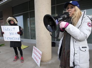 Organizer Renata Huyghebaert (R) and others from the U of S International Women's Movement protest at BHP Billiton's Saskatoon offices because of a dam breaking in Brazil, leading to environmental damage, December 22, 2015.
