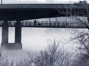 A pedestrian in the fog while walking under the Circle Drive North bridge as temps dipped into the double digits, Tuesday, December 22, 2015.