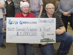 SASKATOON,SK--DECEMBER 23/2015 1224 news lotto winners1 --Donald Hamel (Santa hat) and Gerald Friesen  accept a cheque for $1 million after 18 Sasktel co-workers shared in a MAXMILLIONS prize from the Dec 11/15 LOTTO MAX draw. They were presented the cheque, Wednesday, December 23, 2015. (GREG PENDER/ SASKATOON STARPHOENIX)