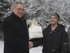 Mayor Don Atchison, left, congratulates Pat Freriks for winning December's Snow Angel recognition,  Wednesday, December 23, 2015. The city recognizes people who go above and beyond to help fellow neighbours keep sidewalks clear of snow.