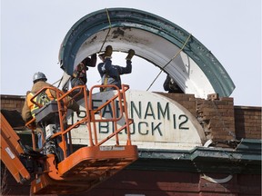 A demolition crew removes the sign from the Farnam Block atop Lydia's.