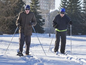 Earl Ripley, left, on snowshoes, and Glenn Kurmey, on skis, get in a workout in the snow in Lakewood Park, on Tuesday, Dec. 1, 2015.