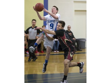 Centennial Chargers' Jeff Erickson (R) tries to block the layup by Bishop James Mahoney guard Ethan Hupe during action in the Bowlt Classic at Evan Hardy Collegiate, December 3, 2015.