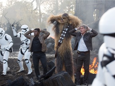 L-R: John Boyega as Finn, Peter Mayhew as Chewbacca and Harrison Ford as Han Solo in "Star Wars: The Force Awakens."