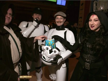 Star Wars fans (from Left to right) Kris Joostin (Jedi), Peter White (Stormtrooper), Jeff Schultz (Stormtrooper) and Dara Defreitas (Sith) all dressed up for the first showing of Star Wars: The Force Awakens as they wait in line at Chinook Centre in SW Calgary, Alta. on Thursday December 17, 2015.