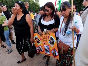 Tina Fontaine, centre, attends a vigil for her daughter Tina Fontaine and Faron Hall at the Oodena Circle at The Forks in Winnipeg, Manitoba, Tuesday, August 19, 2014.