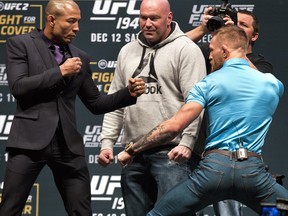 UFC featherweight champion Jose Aldo, left, poses for a photo with his opponent interim UFC featherweight champion Conor McGregor, right, during a UFC 194 news conference at the MGM Grand Garden Arena in Las Vegas, on Dec. 9, 2015.