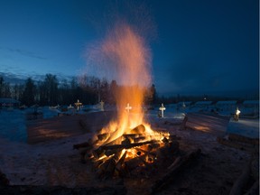 A fire burns as it thaws the frozen ground in order to dig a grave for one of the shooting victims at the cemetery in La Loche, Saskatchewan, Monday, Jan. 25, 2016. A 17-year-old was charged with first-degree murder and attempted murder in a mass shooting at a school and home in the remote aboriginal community in western Canada on Friday, officials said.