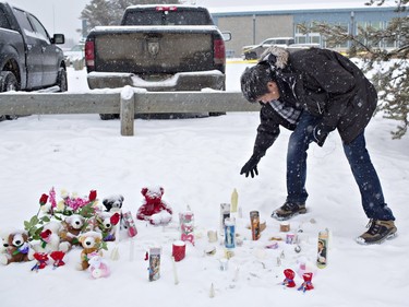 A resident of La Loche pays his respects on January 23, 2016 to the victims of a Friday school shooting. The shooting left four people dead.