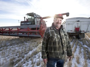 Rick Konotopetz in front of Massey-Ferguson 860 combine on his farm near Perdue, SK.  A dismal growing season forced Konotopetz to leave most of his salvageable crop in the field, but he spent January 4 harvesting about 20 acres of standing wheat.