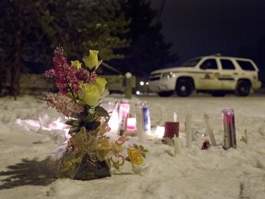 Candles and flowers placed as a memorial lay near the La Loche junior and senior high school as police investigate the scene of a daytime shooting at the school on January 23, 2016.
