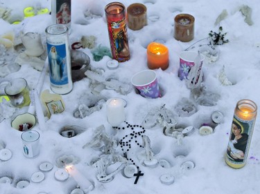 Candles and flowers placed as a memorial lay near the La Loche junior and senior high school on January 23, 2016. A shooting Friday left four people dead.