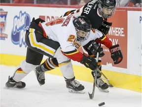 Jonathan Tychonick of the Calgary Flames checks Kobe Walker of the Lloydminster Bandit Pipeline Bobcats at the Scotiabank Saddledome in Calgary, Alta., on Friday, Jan. 1, 2016. It was the male final in the Mac's AAA Midget World Invitational Hockey Tournament Championships.