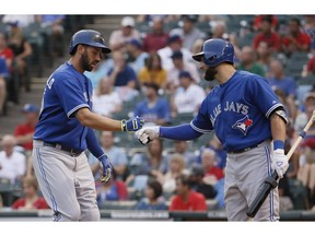 File Photo. Toronto Blue Jays' Chris Colabello, left, celebrates his solo home run with teammate Kevin Pillar during the first inning of a baseball game against the Texas Rangers, Tuesday, Aug. 25, 2015, in Arlington, Texas.