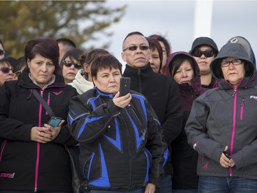 La Loche residents look on as Prime Minister Justin Trudeau (not pictured) lays flowers at a memorial at La Loche Community School on January 29, 2016.