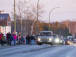 La Loche residents release balloons as a large convoy of vehicles, including two hearses carrying the remains of Dayne and Drayden Fontaine drive down the main street of town on Friday, January 29th, 2016. (Liam Richards/Saskatoon StarPhoenix)