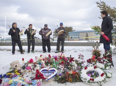 Prime Minister Justin Trudeau lays flowers at a memorial at La Loche Community School on January 29, 2016.