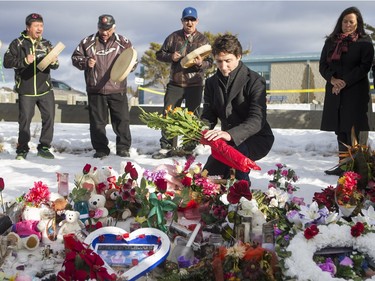 Prime Minister Justin Trudeau lays flowers at a memorial at La Loche Community School on January 29, 2016.