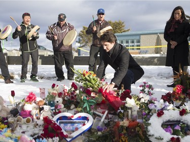 Prime Minister Justin Trudeau lays flowers at a memorial at La Loche Community School on January 29, 2016.